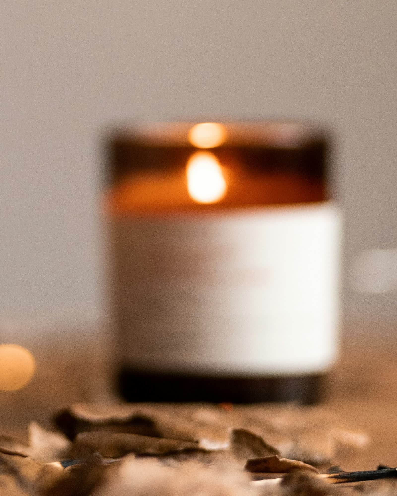 A candle glowing in an amber glass jar